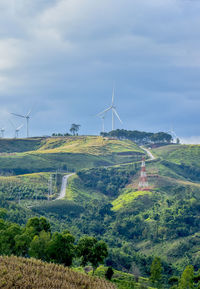 Windmills on field against sky