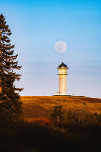 Low angle view of lighthouse amidst buildings against sky