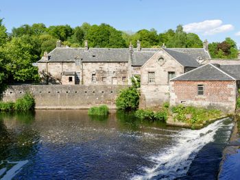 Building by river against sky