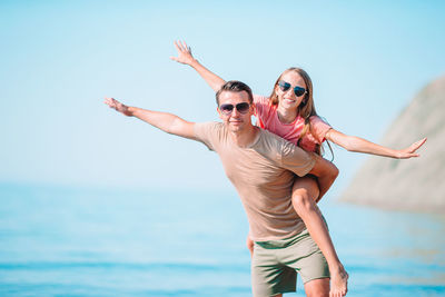 Portrait of father and daughter standing at beach