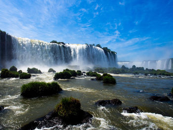 Scenic view of waterfall against sky