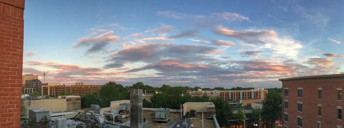 Buildings against cloudy sky at sunset