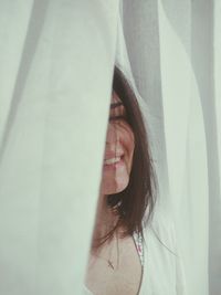 Smiling woman by curtain