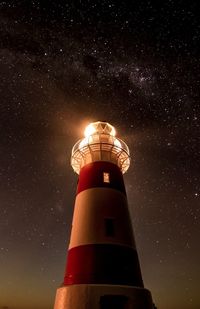 Low angle view of lighthouse against sky at night