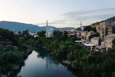 River amidst buildings in town against sky