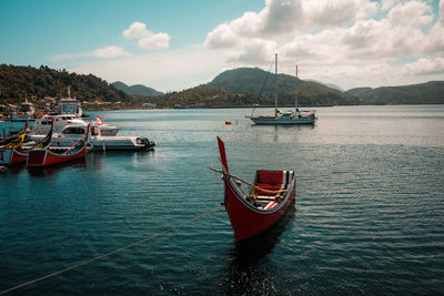 Boat moored on sea against sky