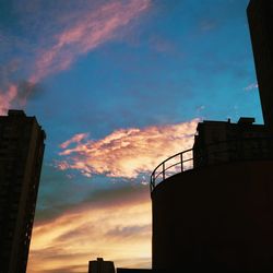 Low angle view of buildings against cloudy sky