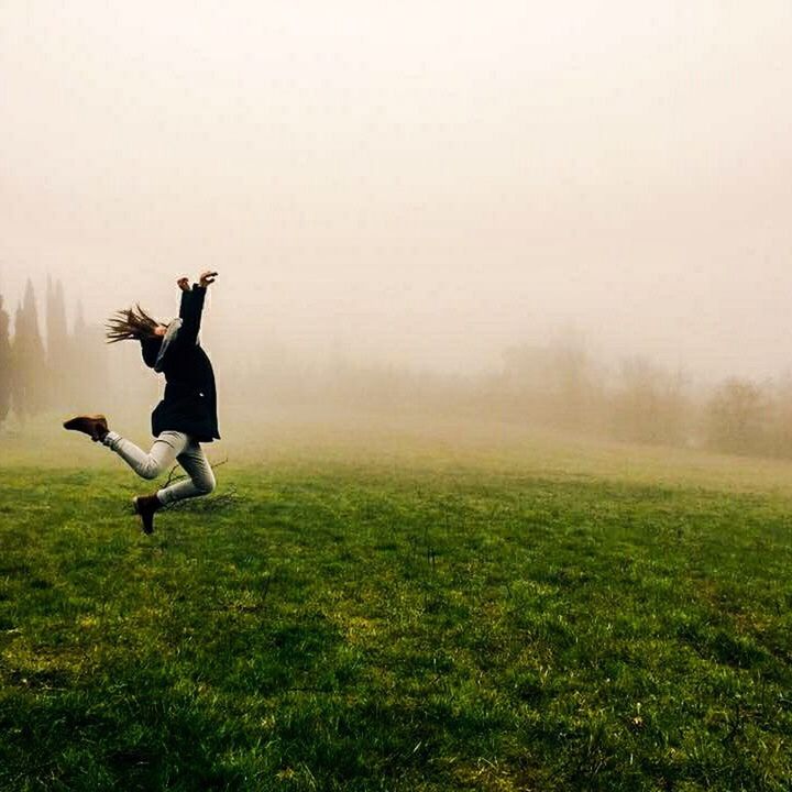 MAN JUMPING ON FIELD AGAINST SKY