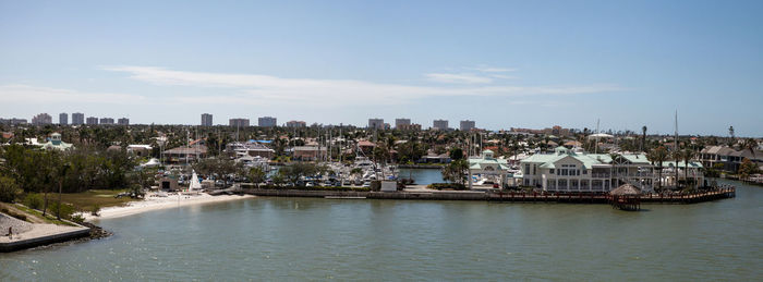 Scenic view of river by buildings against sky