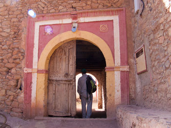 Rear view of man entering into old building