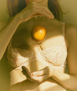 Woman playing with orange in her hands ii