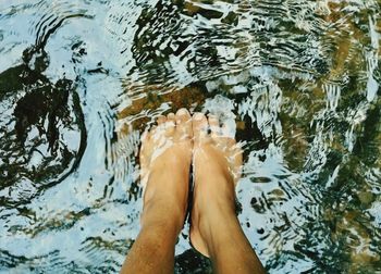 This picture shows a person submerging his feet in very clear water