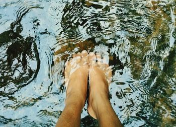 Low section of woman standing in water