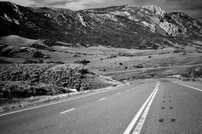 Highway by mountains against sky