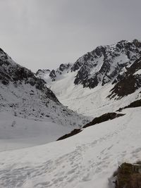 Scenic view of snow covered mountains against sky