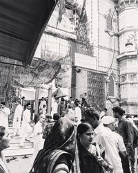 People walking on street amidst buildings in city