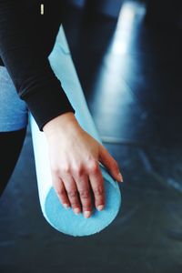 Midsection of woman holding exercise equipment at gym