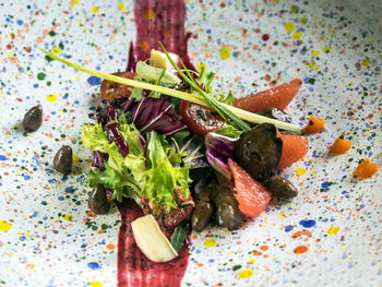 Close-up of quail liver with salad and grapefruit served in plate