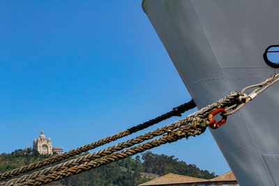 Low angle view of crane against clear blue sky