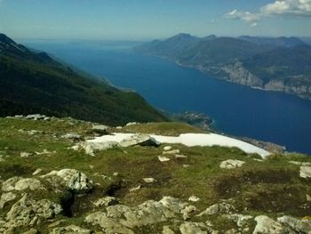 View of calm blue sea against mountain range