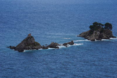 Rock formation in sea against sky