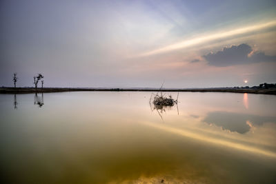 Scenic view of lake against sky at sunset