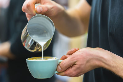 Midsection of man preparing coffee at cafe