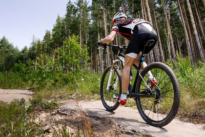 Low section of man riding bicycle on road