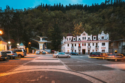 Cars on street against sky during sunset