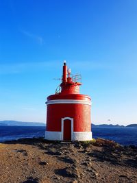 Lighthouse by sea against sky