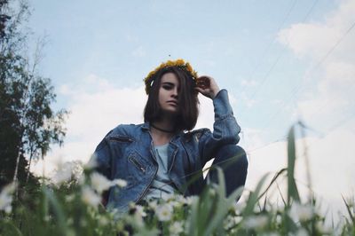 Low angle view of young woman against sky