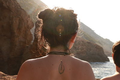 Rear view of shirtless woman at beach