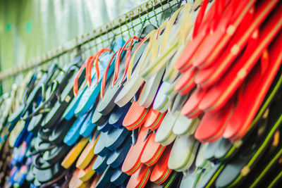 Low angle view of multi colored slippers hanging in market for sale