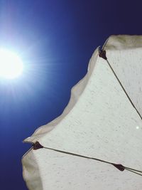 Low angle view of umbrella against clear sky on sunny day