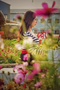 Side view of woman sitting amidst plants in park