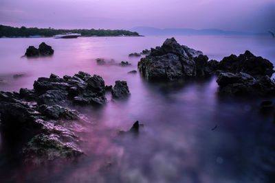 Scenic view of rocks in sea against sky