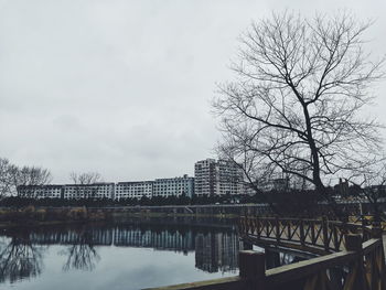 Bridge over river in city against sky