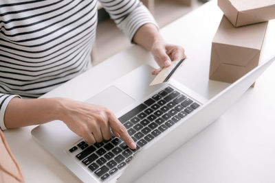 High angle view of woman using laptop on table at home