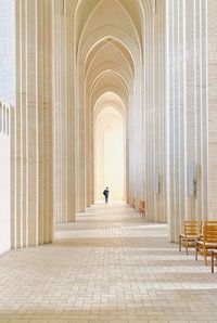 Rear view of person walking in corridor of building