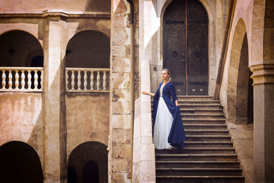 Full length of woman standing against building