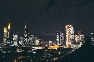 Illuminated buildings in city against sky at night