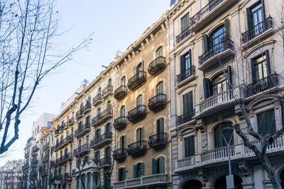 Low angle view of buildings in city against sky during winter