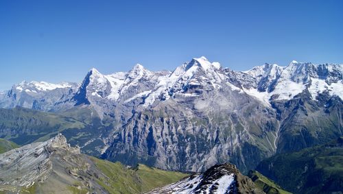 Scenic view of snowcapped mountains against clear blue sky