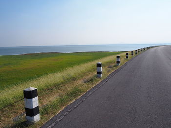 Road by sea against clear sky