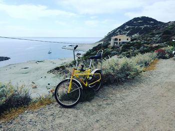 Bicycles on beach against sky