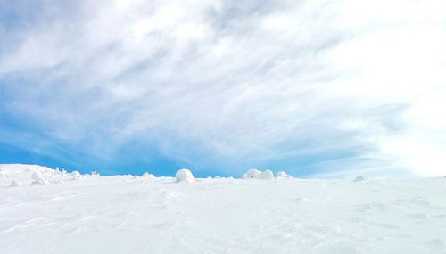 Snow covered landscape against sky