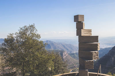 Stack of wood against mountains