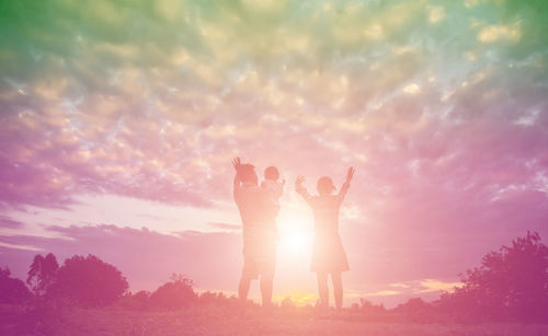 Friends standing against sky during sunset