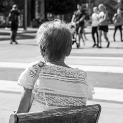 Rear view of couple sitting on street