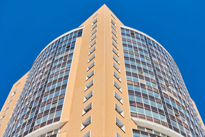 Low angle view of modern building against clear blue sky